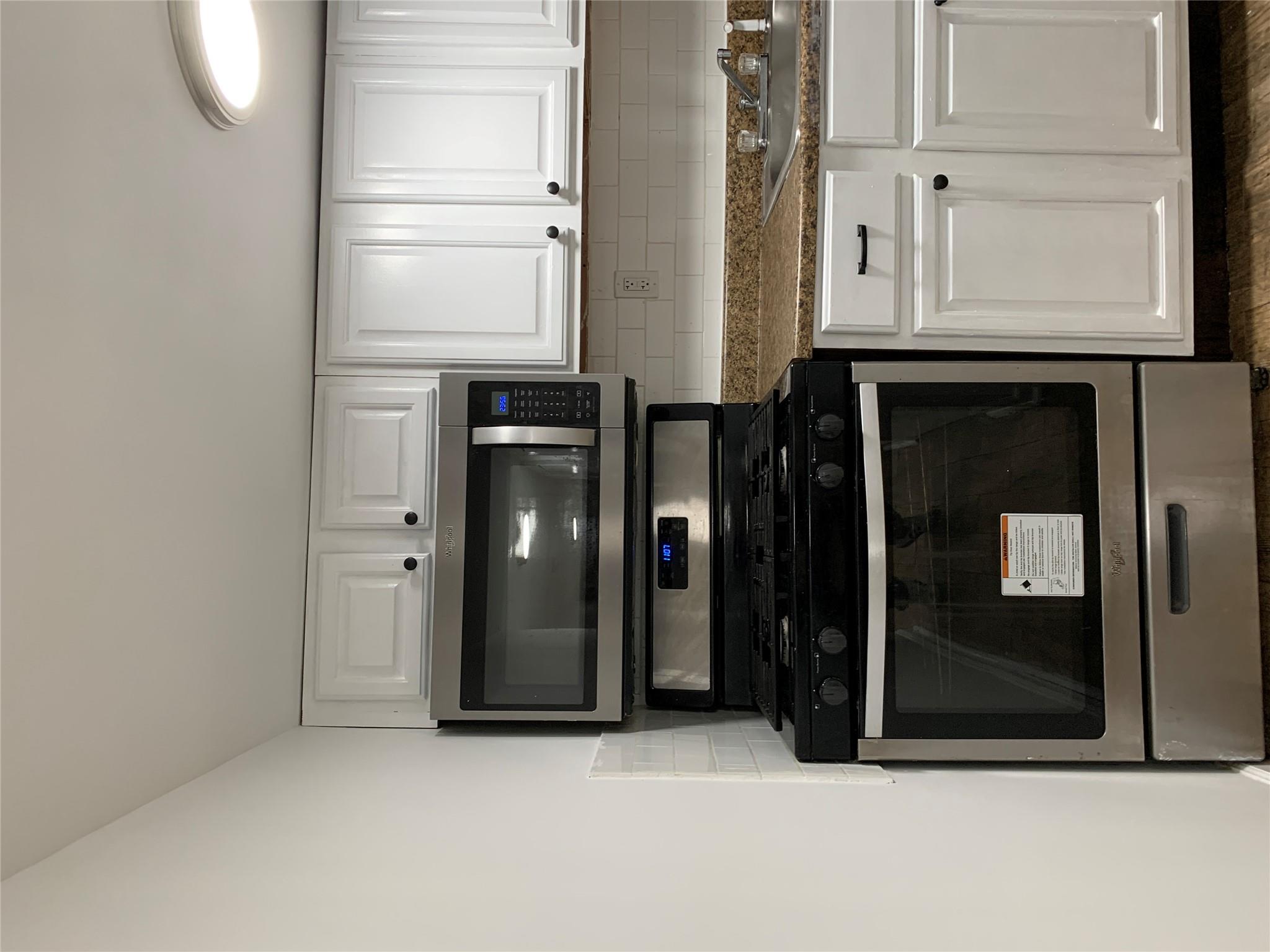 2263 Ryer Avenue Bronx, NY 10457 - Photo 42 of 49 Kitchen with a sink, range, stainless steel microwave, and backsplash