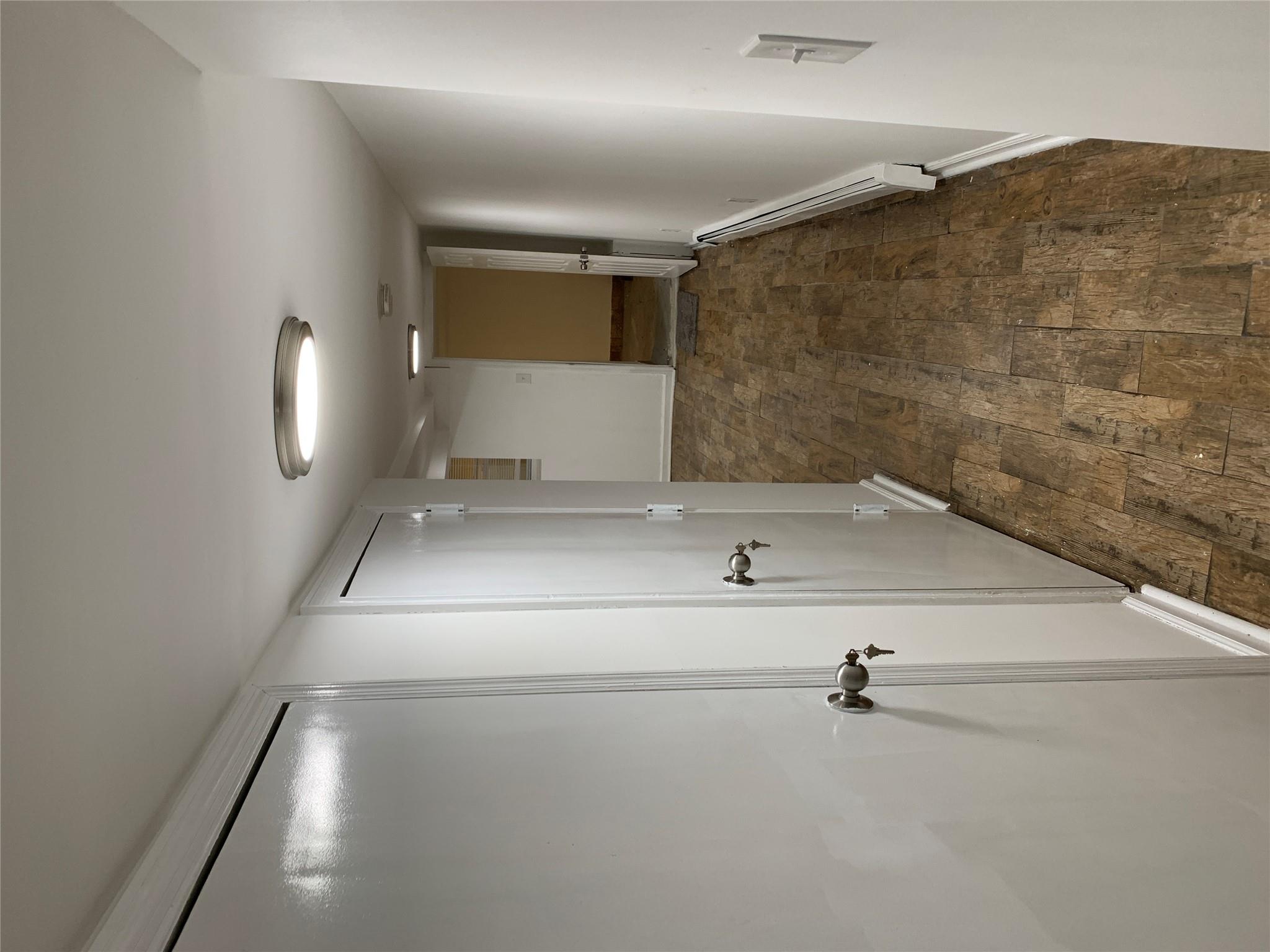 2263 Ryer Avenue Bronx, NY 10457 - Photo 47 of 49 Hallway with dark wood-style flooring, baseboards, and a baseboard heating unit