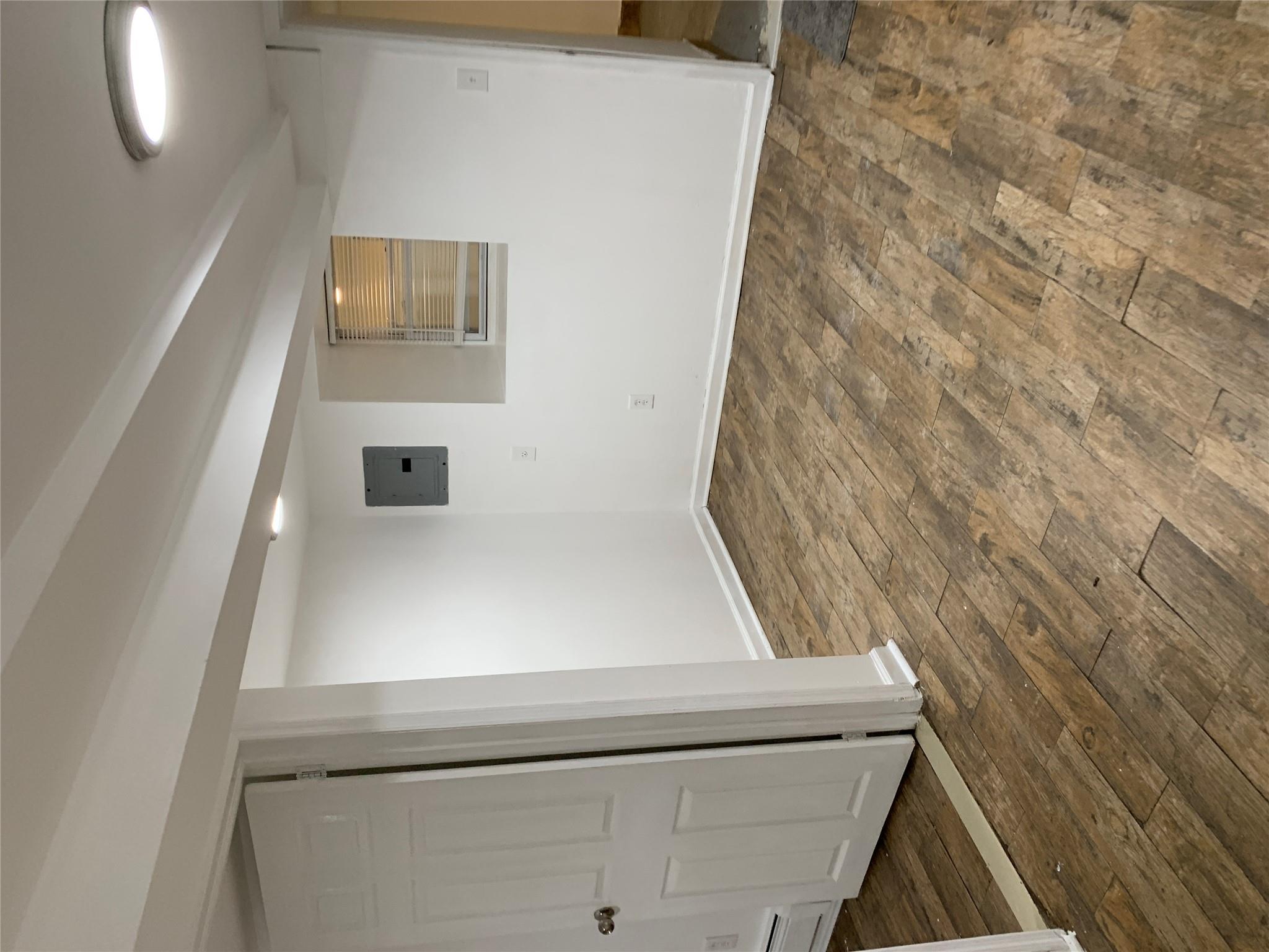 2263 Ryer Avenue Bronx, NY 10457 - Photo 48 of 49 Finished basement featuring electric panel, dark wood-style floors, baseboard heating, and baseboards