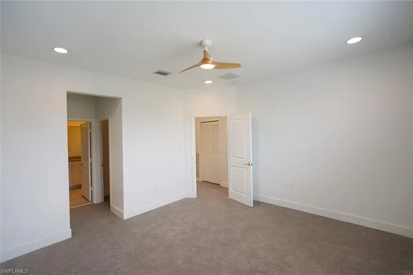 an empty room with closet and a chandelier fan