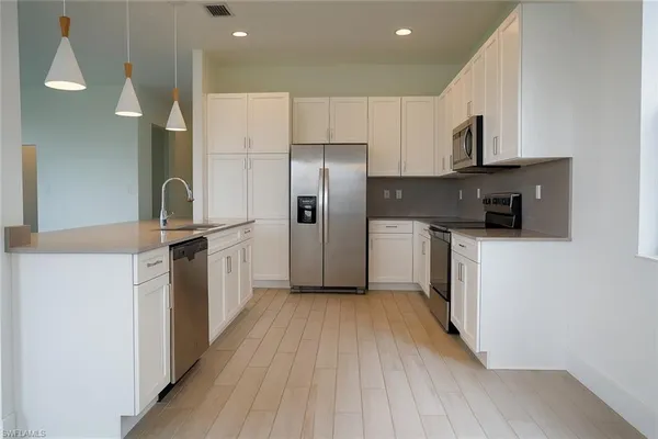 a kitchen with stainless steel appliances a refrigerator sink and microwave