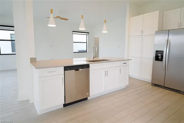 a kitchen with white cabinets appliances and sink