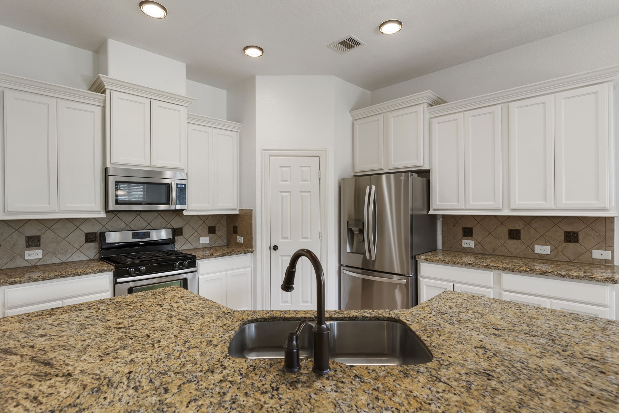 71 Sagamore Ridge Place The Woodlands, TX 77389 - Photo 13 of 34 a kitchen with stainless steel appliances granite countertop a refrigerator and a sink