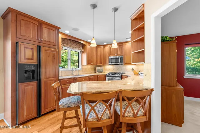 a dining room with stainless steel appliances a table and chairs