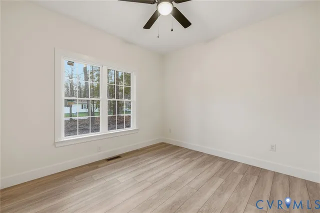 an empty room with a window and a ceiling fan