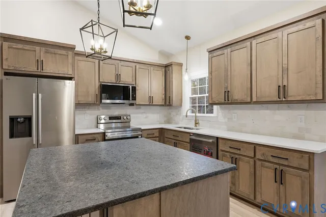 a kitchen with kitchen island a sink stainless steel appliances and white cabinets