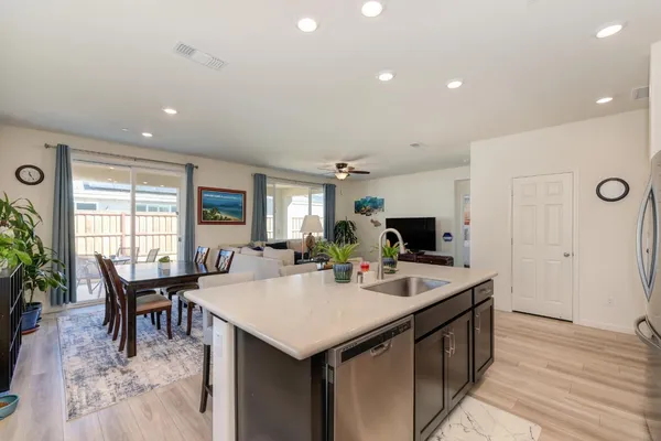 a kitchen with a dining table chairs and flat screen tv