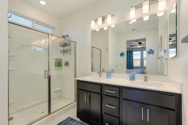 a bathroom with a double vanity sink mirror and shower