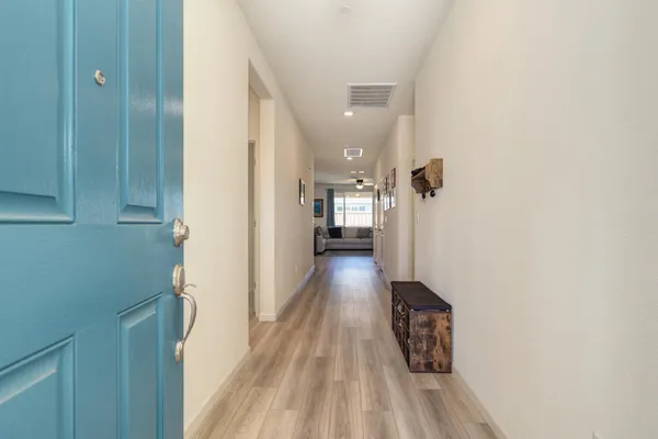 a view of a hallway with wooden floor and staircase