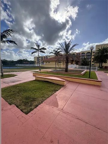 a living room with a black white checkered floor with a gaming machine and a table