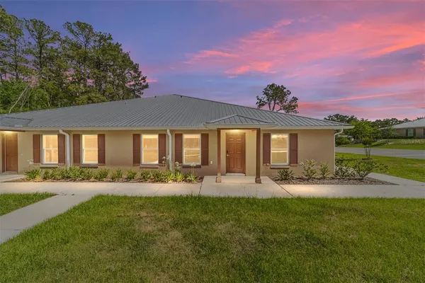 a front view of a house with a yard and outdoor seating