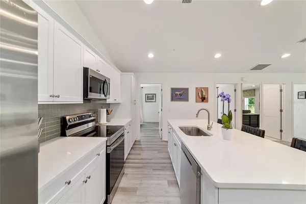 a large white kitchen with stainless steel appliances