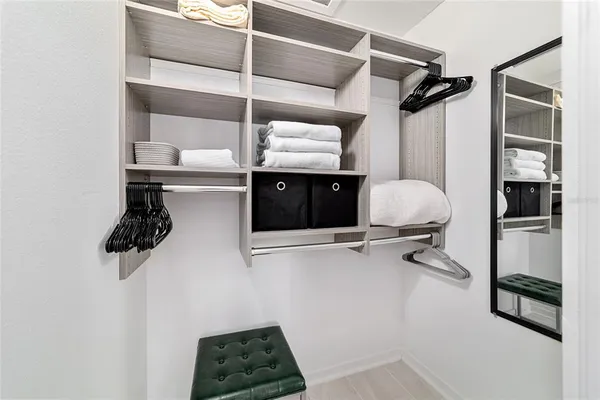 a view of walk in closet with clothes and shoes