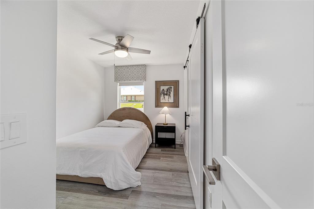 4400 Northwest 74th Terrace Ocala, FL 34482 - Photo 26 of 39 a bed room with a bed and a chandelier