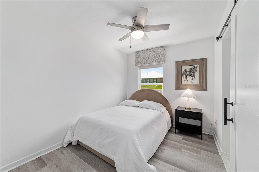 4400 Northwest 74th Terrace Ocala, FL 34482 - Photo 27 of 39 a bedroom with a bed and a chandelier