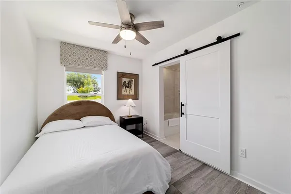 a spacious bedroom with a bed and a chandelier