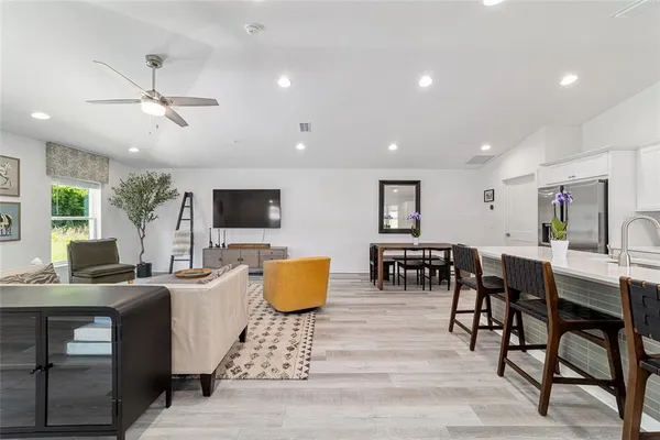 a living room with furniture a flat screen tv and kitchen view