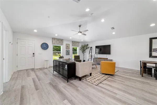 a living room with furniture a flat screen tv and a table