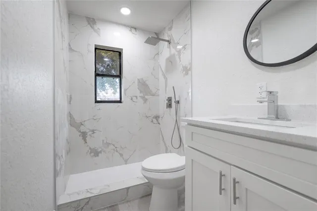 a bathroom with a sink a toilet and shower