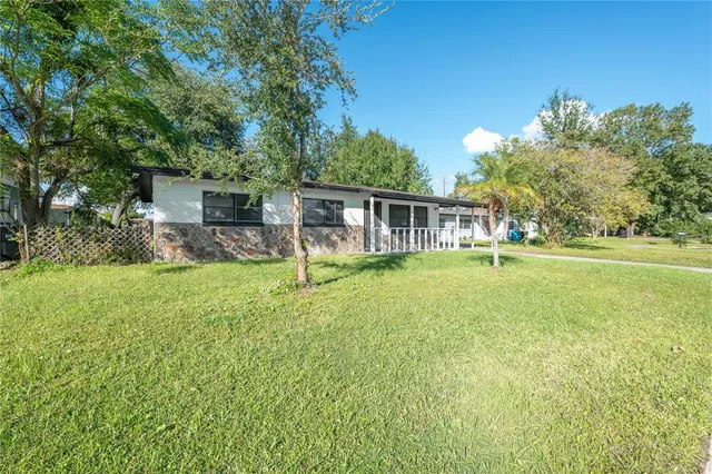 a view of a house with a backyard and a patio
