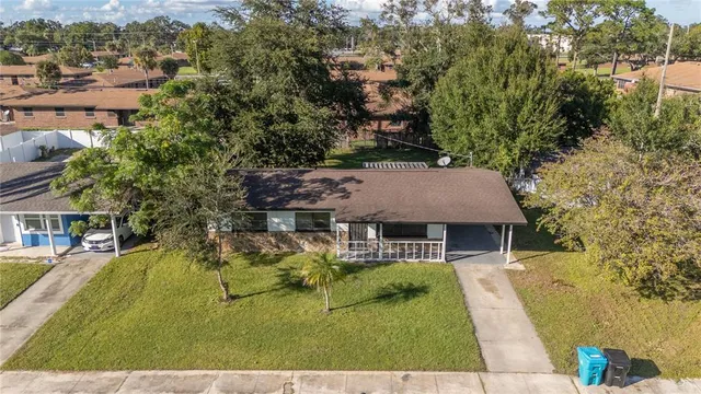 a aerial view of a house with swimming pool and large trees
