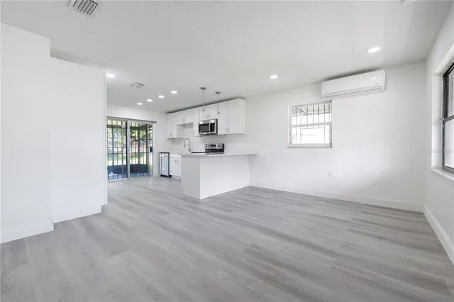 a view of kitchen with wooden floor and electronic appliances
