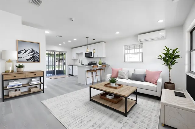 a living room with furniture and a potted plant on a bookshelf