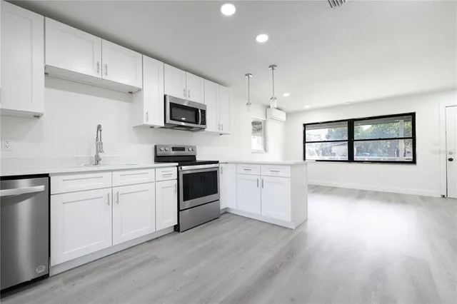 a kitchen with a white cabinets and window