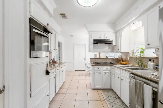 a kitchen with stainless steel appliances a refrigerator sink and microwave