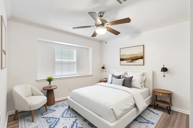 a bedroom with a bed a couch and a potted plant