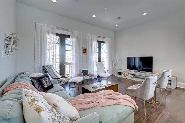 a living room with furniture wooden floor and a large window