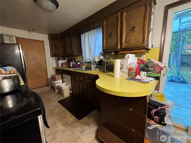 a kitchen with sink refrigerator dining table and chairs