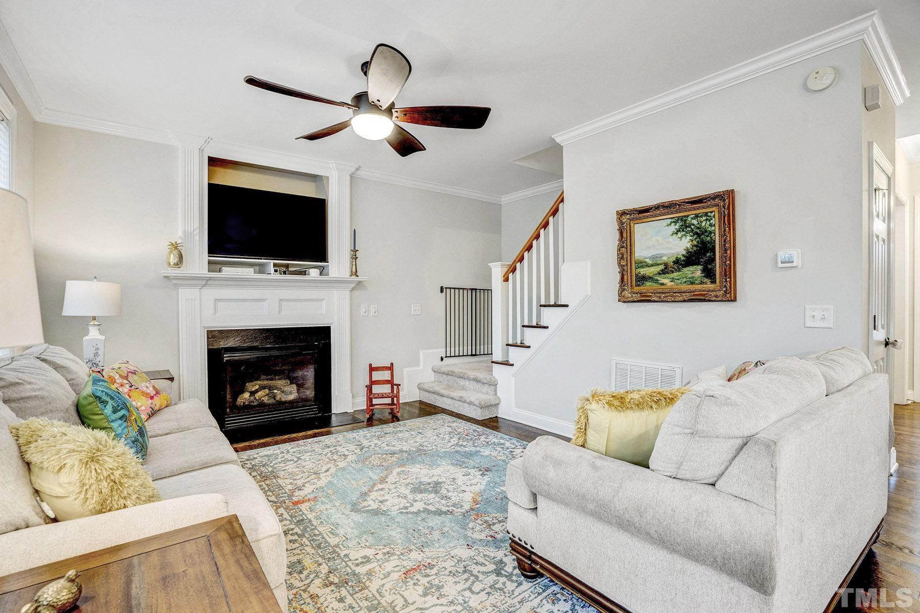 4933 Contender Drive Raleigh, NC 27603 - Photo 19 of 37 a living room with furniture a flat screen tv and a fireplace