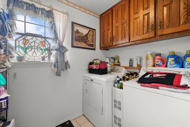 a utility room with fridge dryer and washer