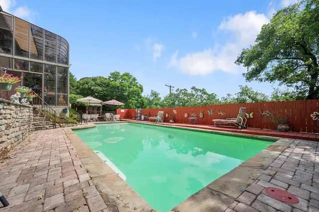a view of a swimming pool with a patio and a garden