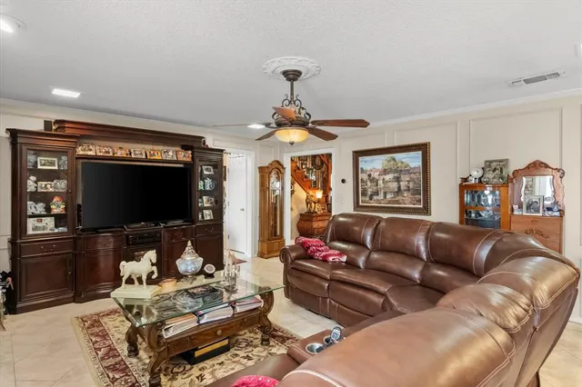 a living room with furniture a ceiling fan and a window