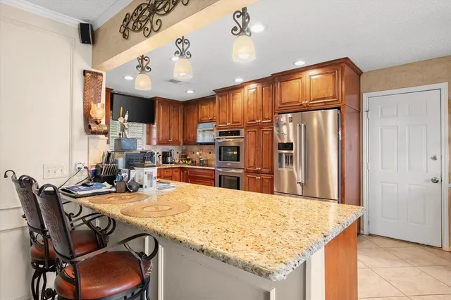 a kitchen with granite countertop a table chairs microwave and cabinets