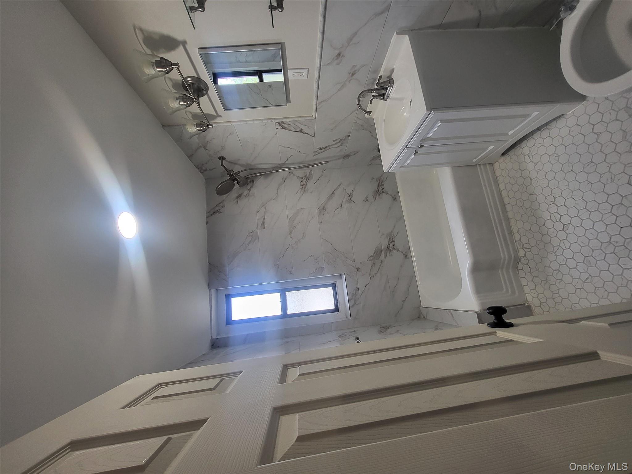 Undisclosed Address Queens, NY 11423 - Photo 13 of 22 Bathroom with vanity, tile walls, and shower combination