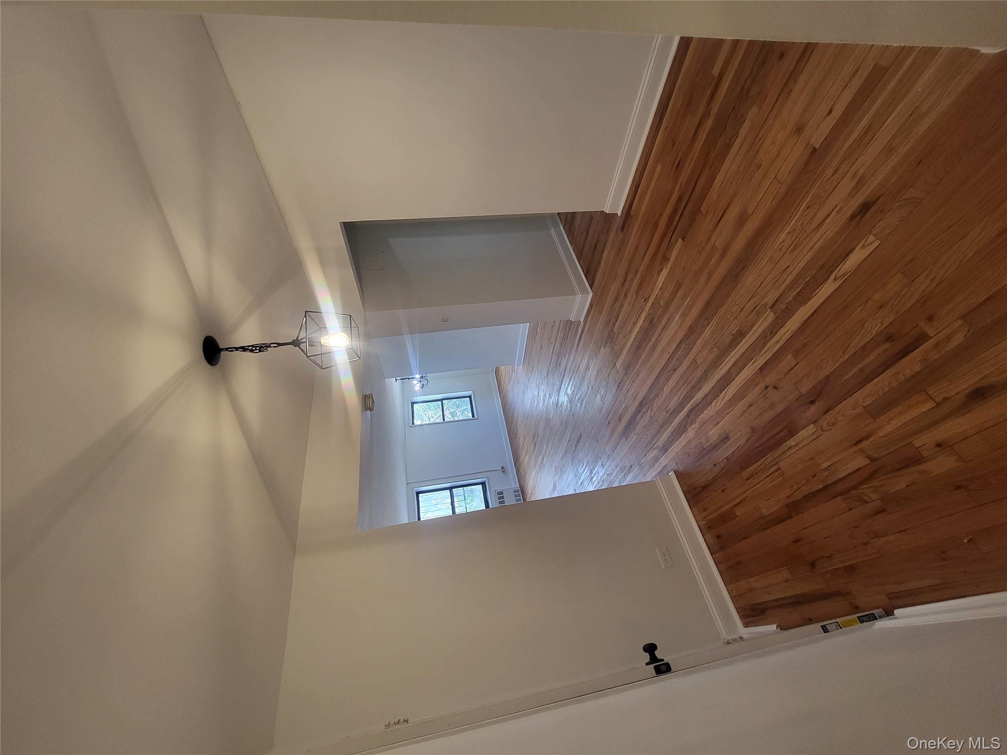 Undisclosed Address Queens, NY 11423 - Photo 18 of 22 Unfurnished dining area featuring dark wood-style flooring and baseboards