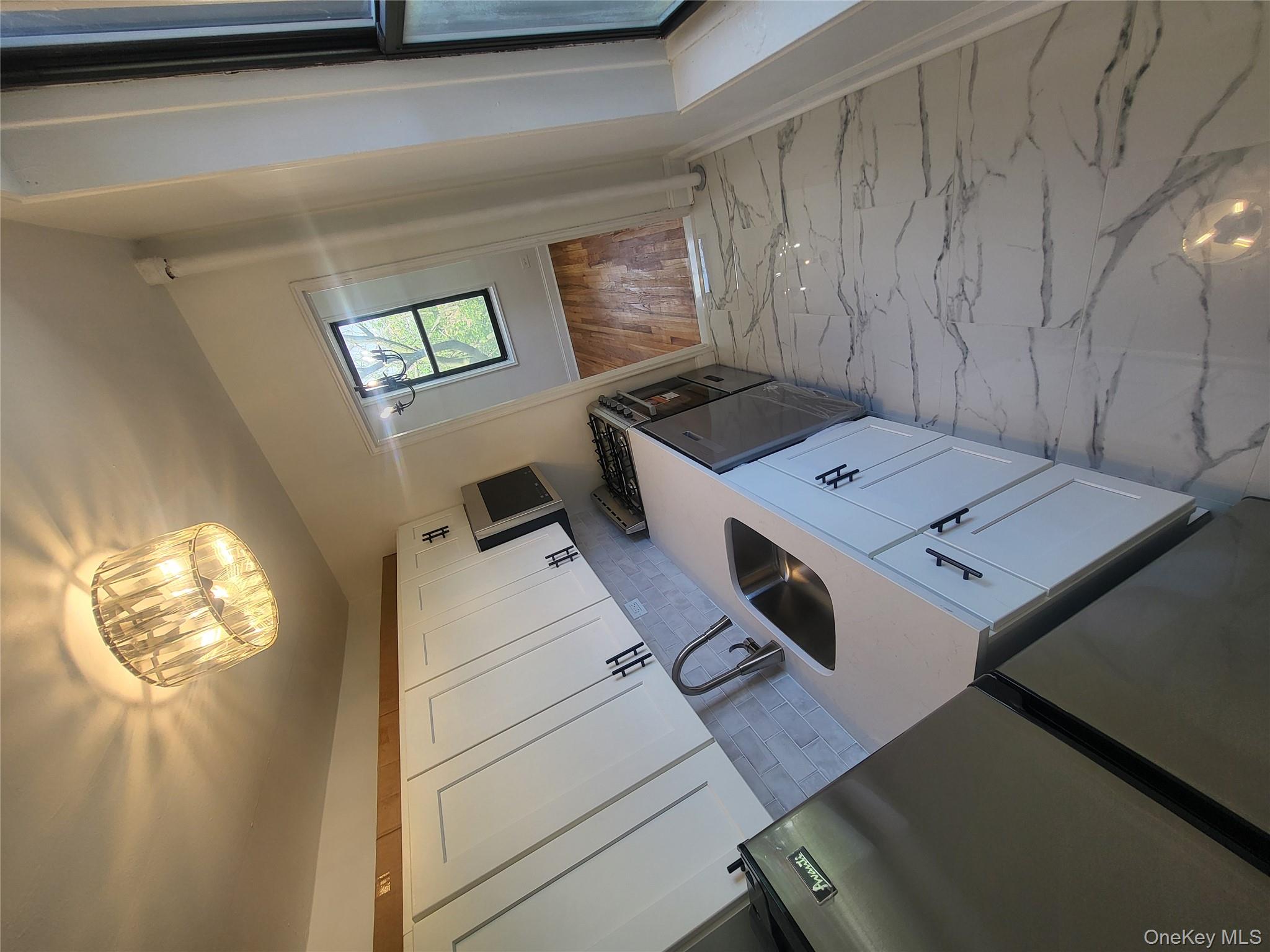 Undisclosed Address Queens, NY 11423 - Photo 4 of 22 Kitchen with light marble finish floors, white cabinets, gas range, dishwashing machine, and refrigerator