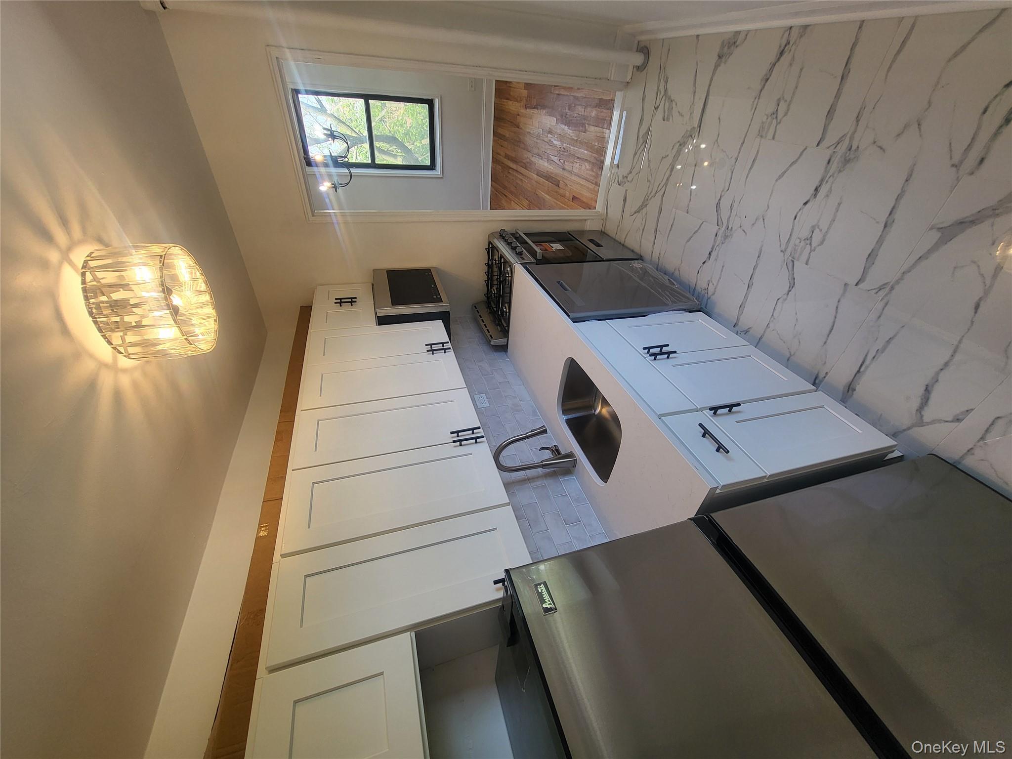 Undisclosed Address Queens, NY 11423 - Photo 5 of 22 Kitchen with refrigerator, white cabinetry, light marble finish flooring, range, and light stone countertops