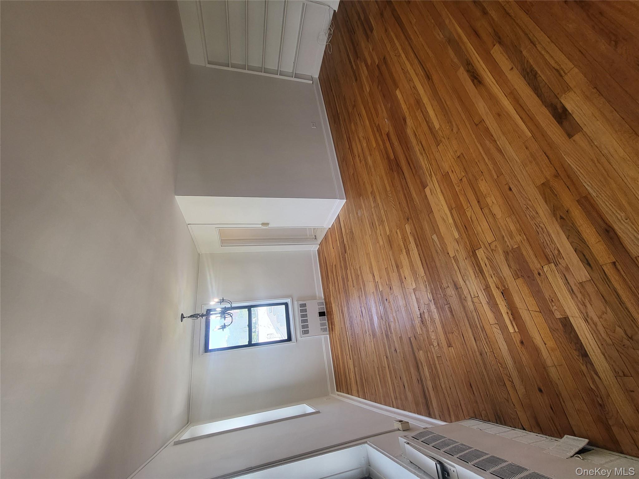 Undisclosed Address Queens, NY 11423 - Photo 6 of 22 Unfurnished living room with light wood-style flooring, a chandelier, and radiator