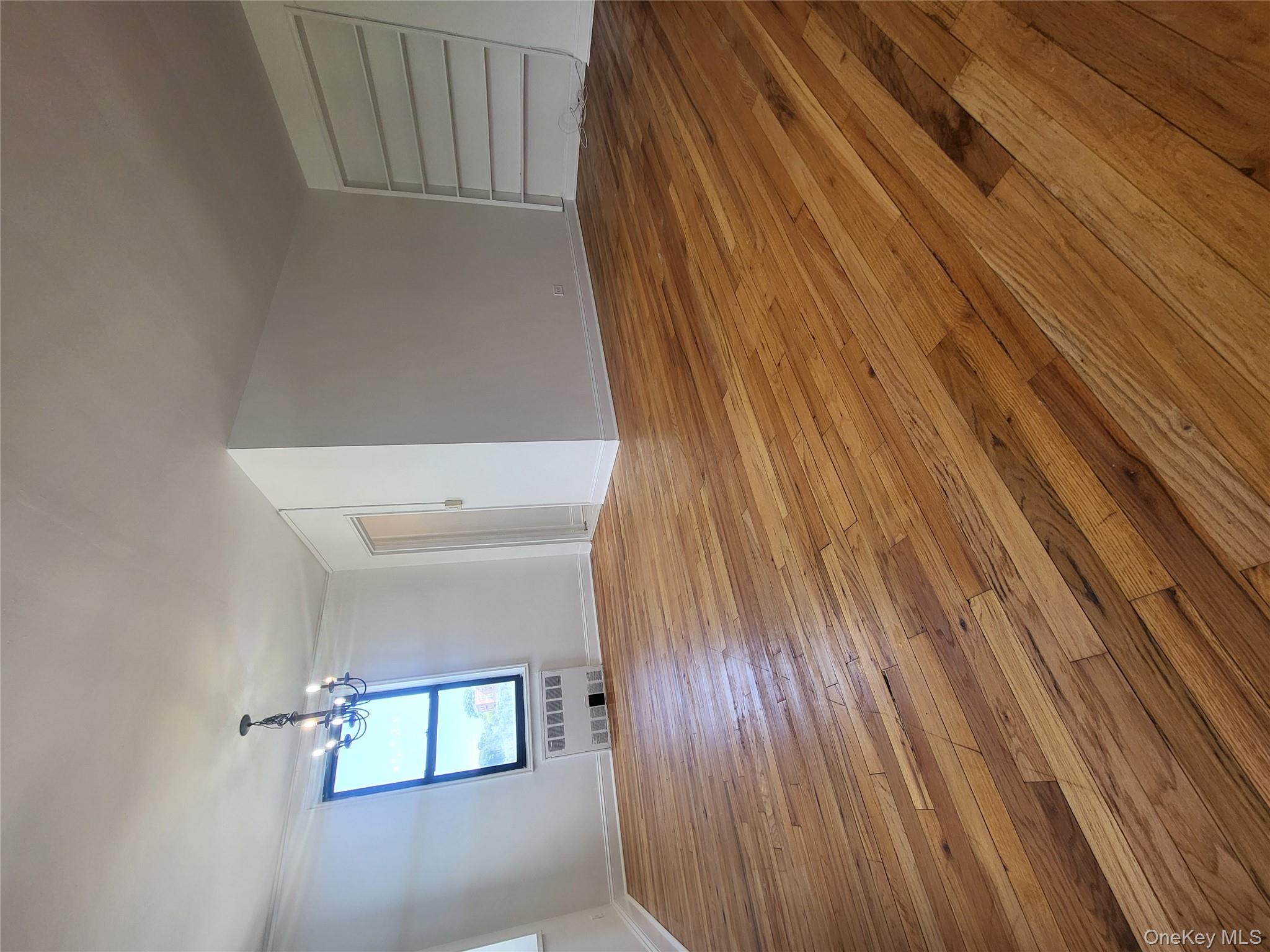 Undisclosed Address Queens, NY 11423 - Photo 7 of 22 Unfurnished living room featuring a chandelier, light wood-style floors, and radiator