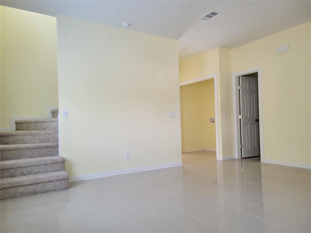 4714 Frank Street Dallas, TX 75210 - Photo 13 of 22 a view of an empty room with wooden floor and a window