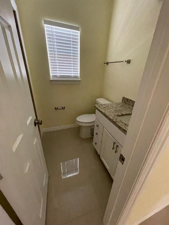 4714 Frank Street Dallas, TX 75210 - Photo 16 of 22 a bathroom with a granite countertop toilet sink and mirror