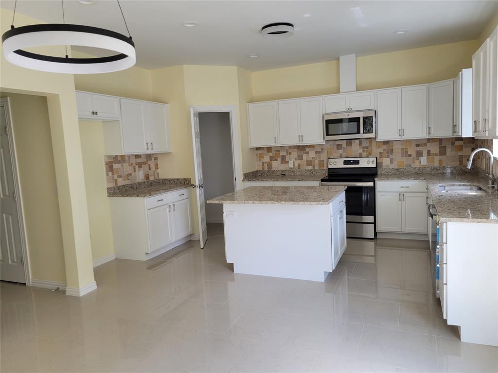 4714 Frank Street Dallas, TX 75210 - Photo 5 of 22 a kitchen with stainless steel appliances a white refrigerator a stove a sink and a refrigerator