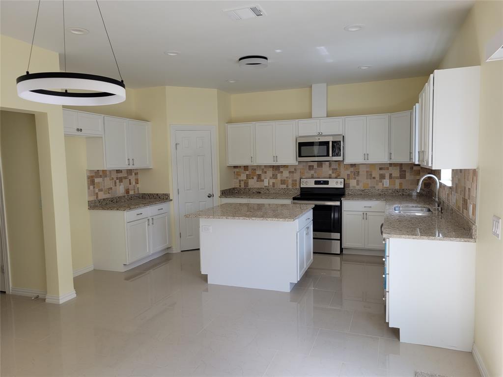 4714 Frank Street Dallas, TX 75210 - Photo 6 of 22 a kitchen with stainless steel appliances granite countertop a stove a sink and a refrigerator