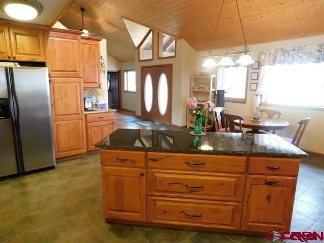 a kitchen with granite countertop a sink a counter top space stainless steel appliances and cabinets