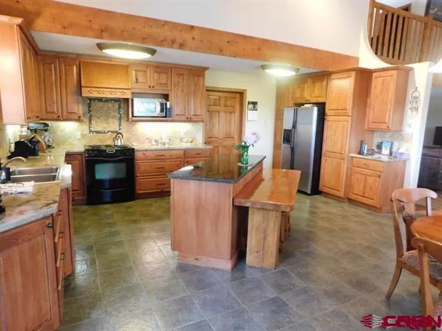 a kitchen with stainless steel appliances granite countertop a refrigerator and a stove top oven