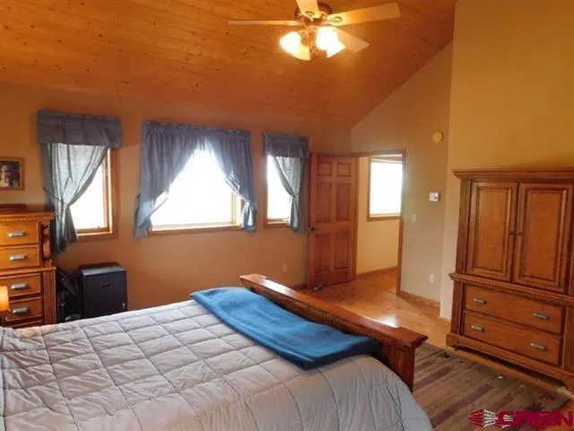 a walk in closet with wooden floor
